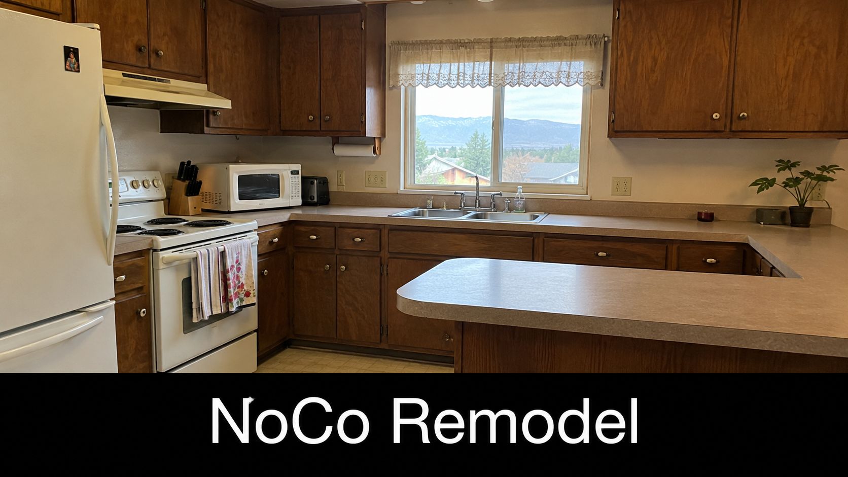 A classic kitchen with wooden cabinets, a white stove, and a view of mountains from the window.